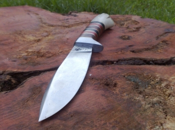 Drop point hunter with stacked handle made from Camphor, Red Ivory and Ebony with a piece of fallow deer antler for the butt.  Blade forged from 5160 spring steel